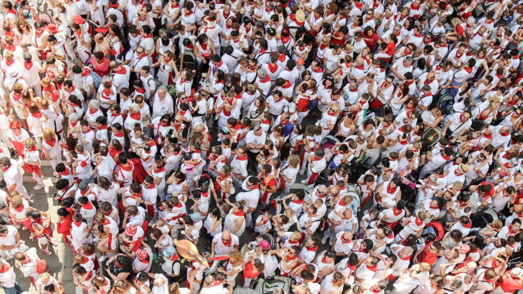 Crowd of revelers during the day, in sun and shade, enjoying the fiesta - shows how crowded it gets.