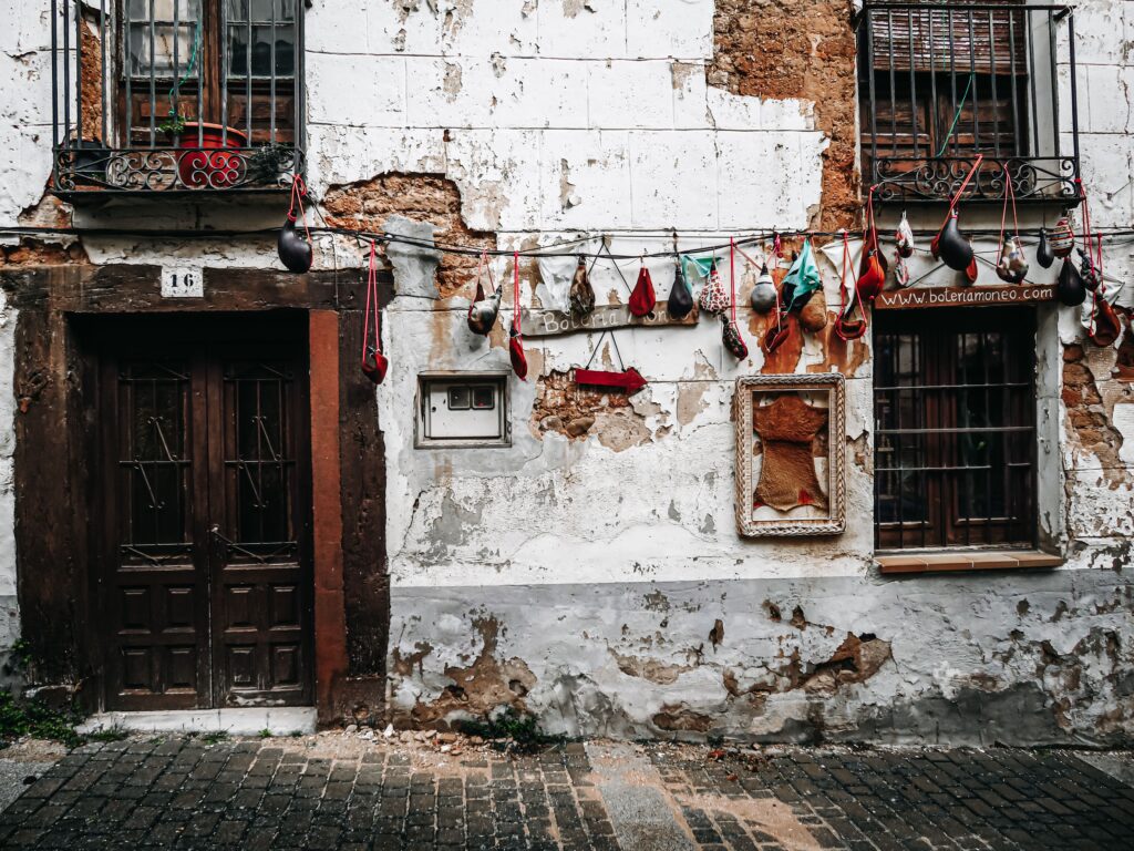 Traditional bota bag wineskins displayed on a weathered wall in a Spanish street, Pamplona