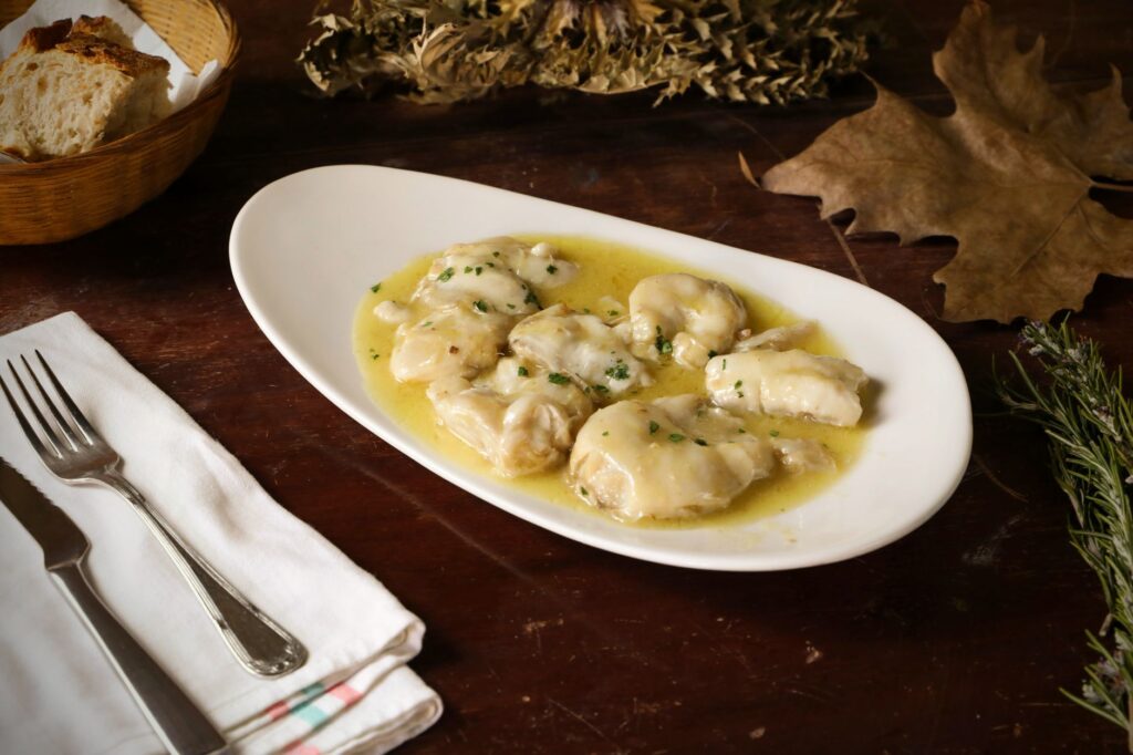 Bacalao al pil pil, cod pieces in a pale emulsified garlic and olive oil sauce