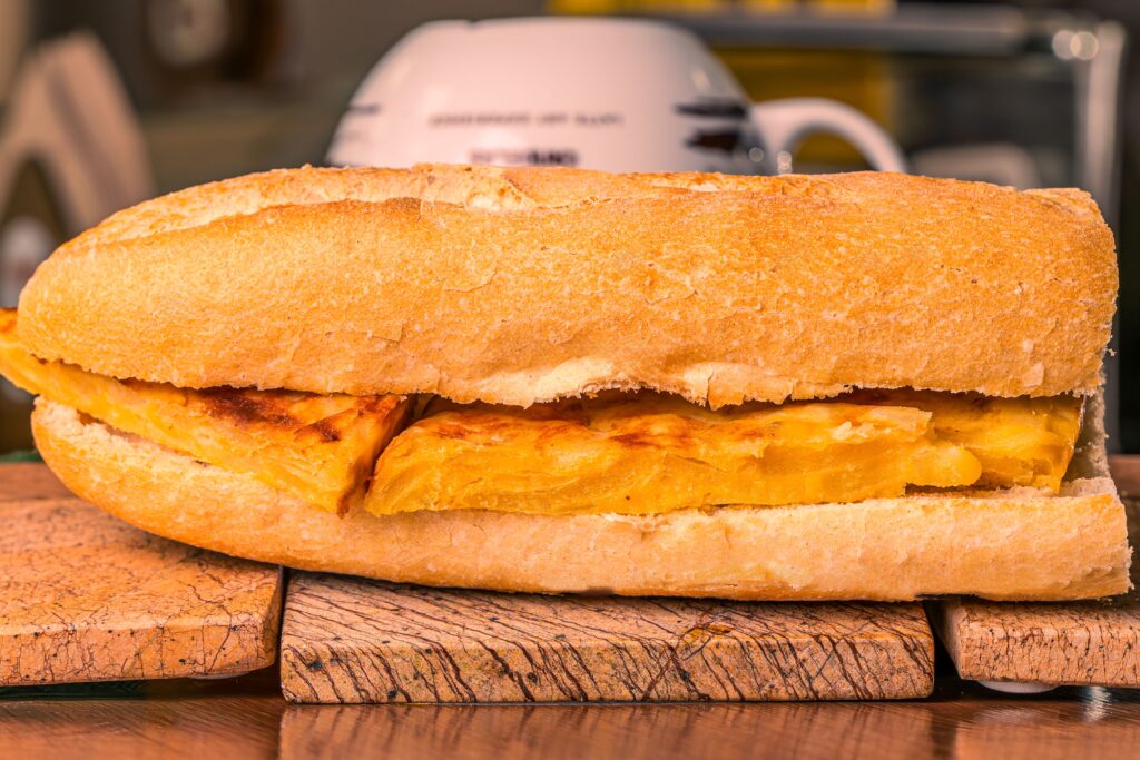 Tortilla de patatas bocadillo on a wooden board, San Fermin fiesta food
