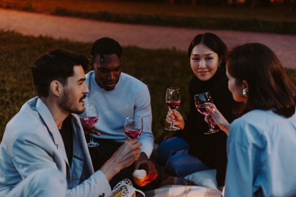 Friends drinking wine outdoors at dusk, botellón street gathering, San Fermín