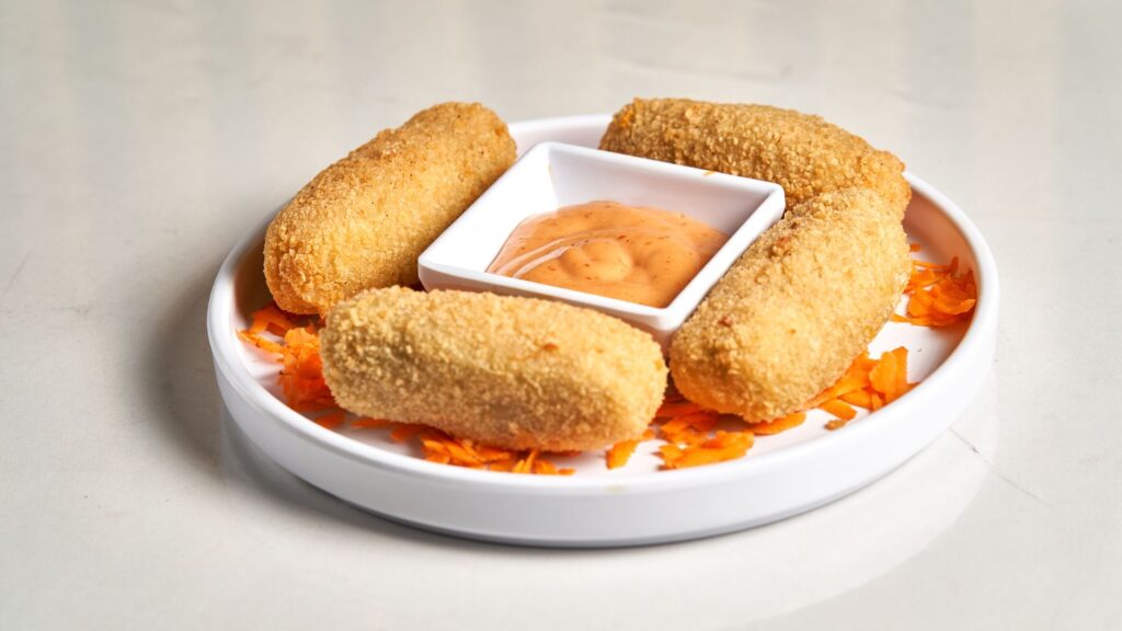 Golden fried croquetas with dipping sauce, a classic Pamplona bar tapa