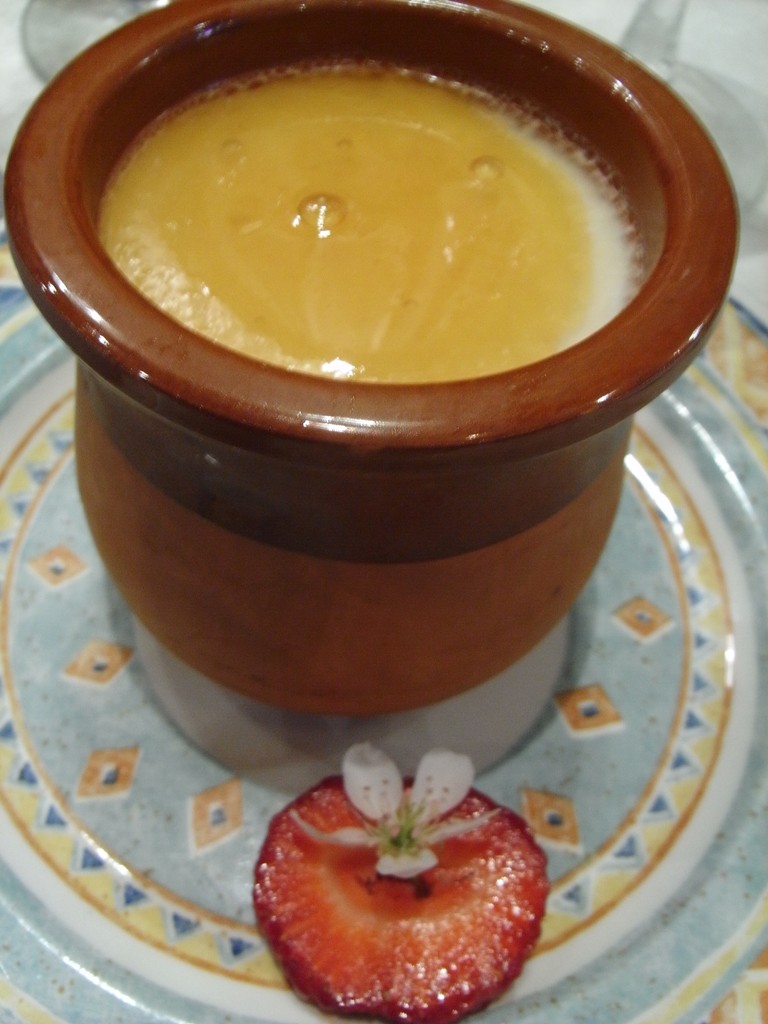 Homemade cuajada dessert with honey in a traditional clay cup
