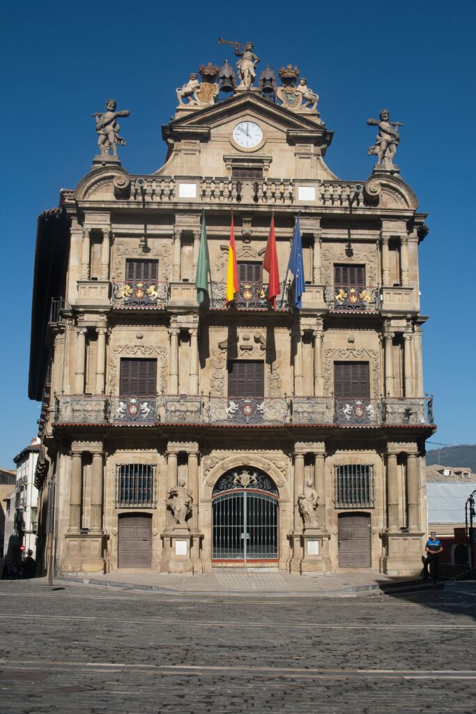 Pamplona's Ayuntamiento facade with Navarra and Spanish flags, seat of the region's civic ceremonies