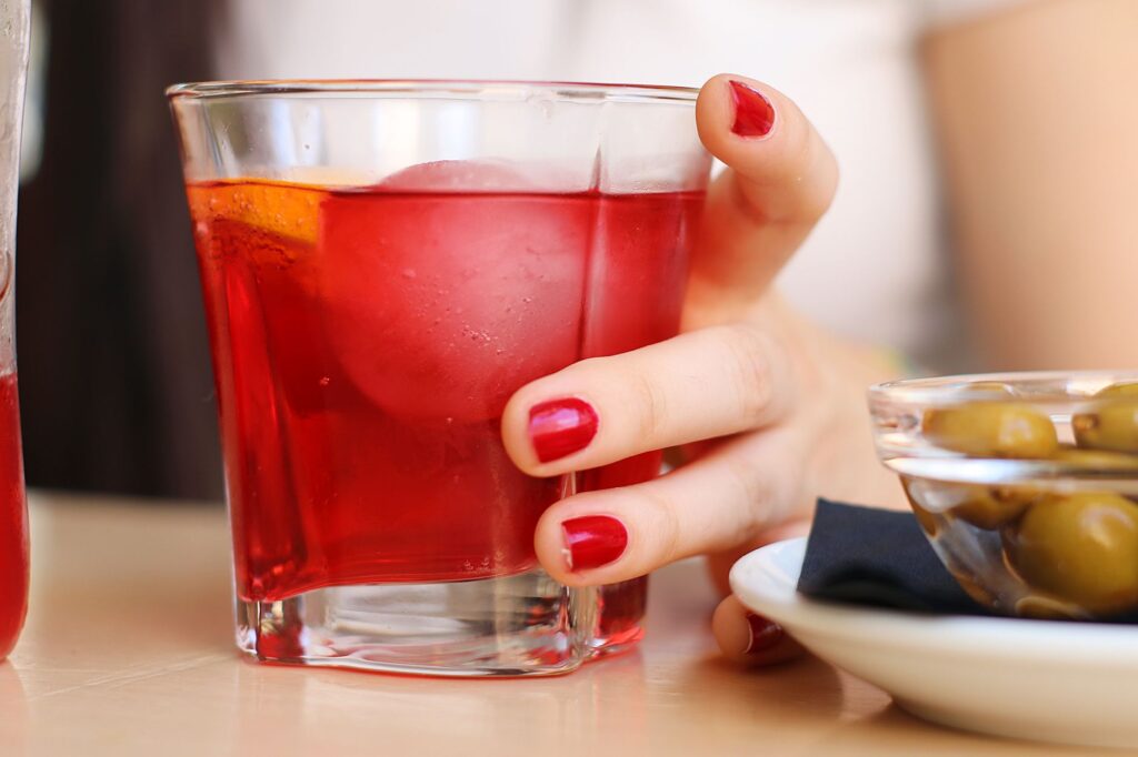 Red aperitif drink garnished with olives, evoking Pamplona's hora del vermut ritual
