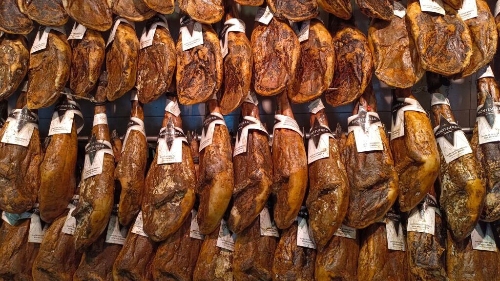 Rows of jabugo iberico ham legs hanging in a traditional Spanish curing bodega
