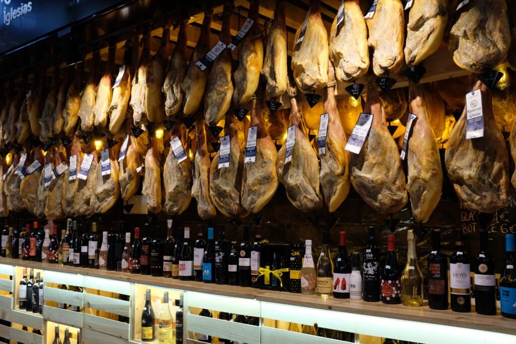 Whole jamón ibérico legs hanging above a Spanish bar counter