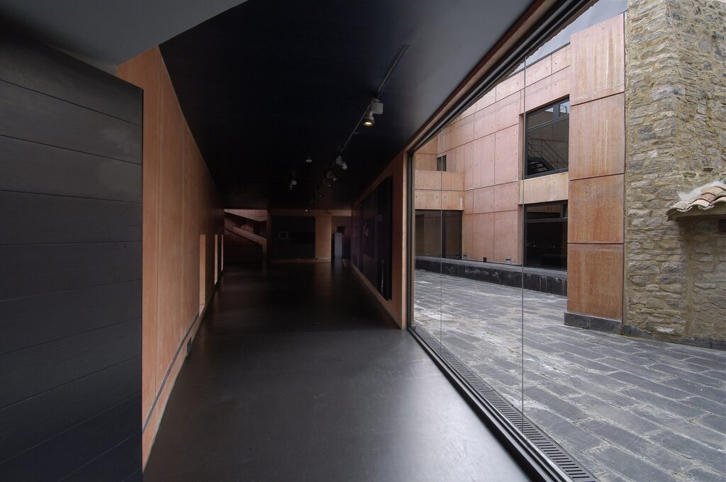 Glazed gallery and red concrete facade of the Jorge Oteiza Museum beside the sculptor's stone farmhouse, Alzuza, Navarra