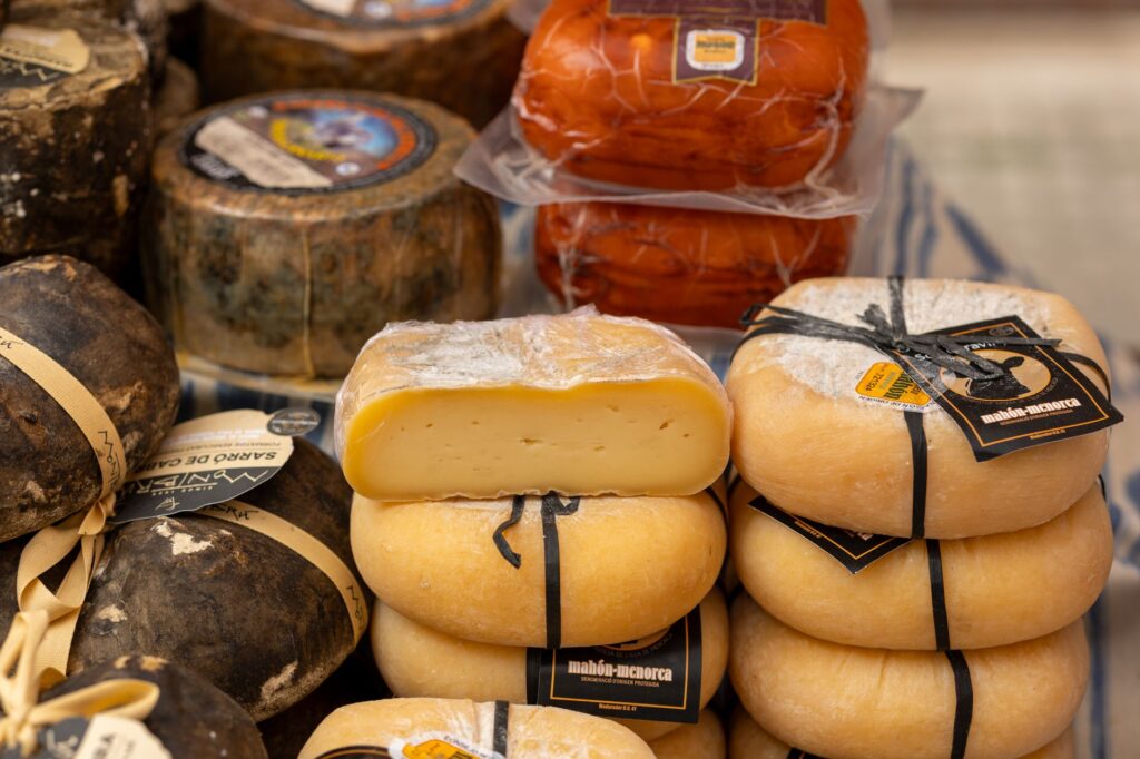 Wheels of traditional Spanish sheep cheese including manchego on a market stall counter, Spain