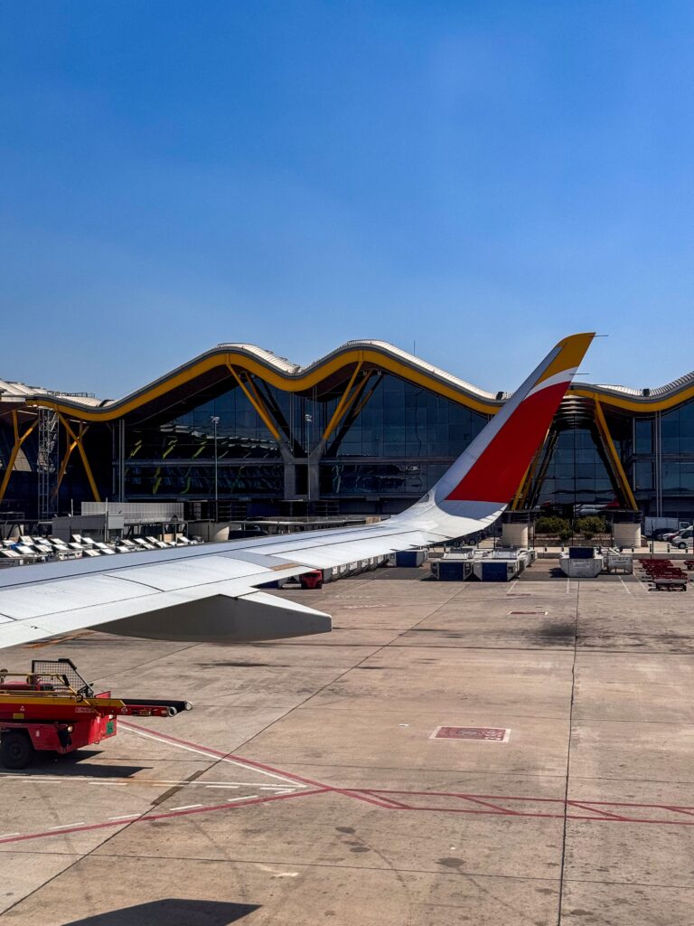Iberia plane wing over a Spanish airport terminal, the airline that flies Pamplona's Madrid route