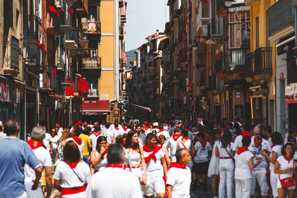 Crowd dressed in white with red panuelos filling a Pamplona street during the San Fermin festival