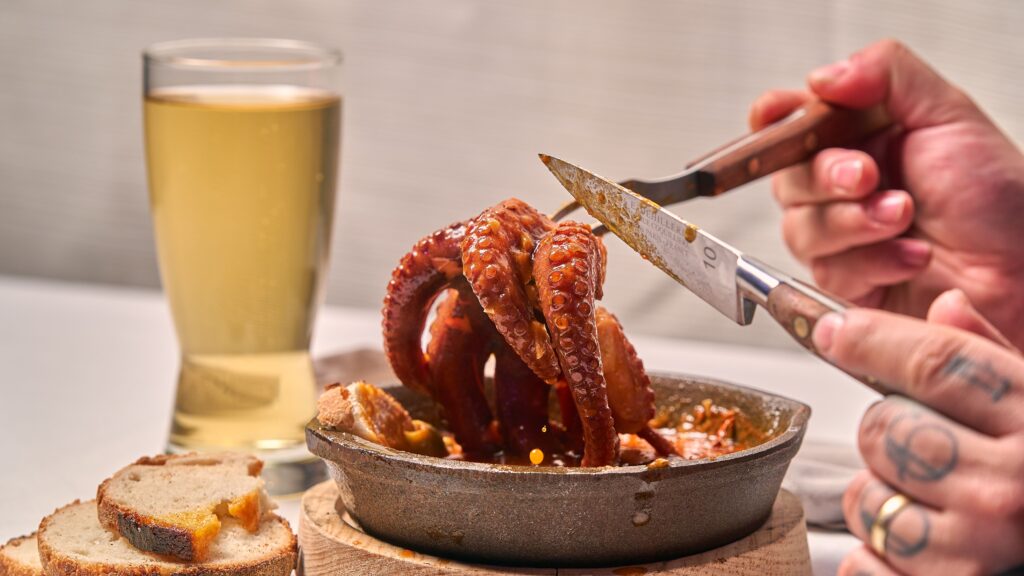Sliced octopus tentacles served with bread, pulpo a la gallega style