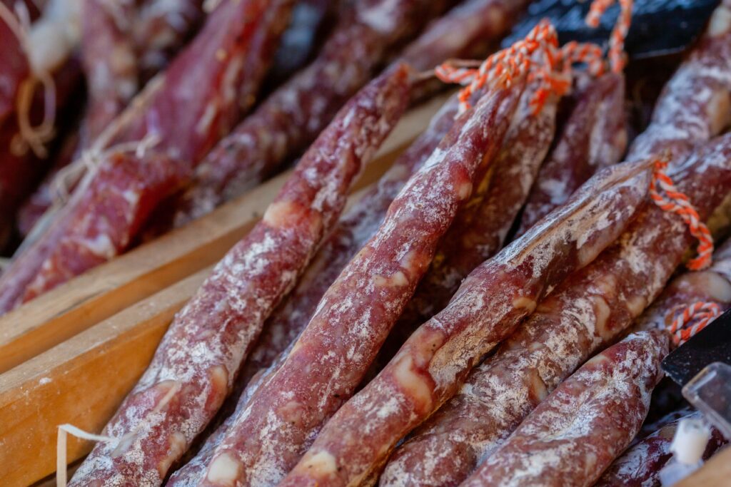 Sliced fuet and salchichón cured sausage displayed at a market stall