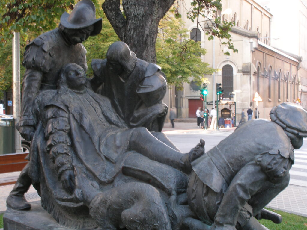 Bronze monument of wounded Ignacio de Loyola carried on a stretcher, Avenida de San Ignacio, Pamplona