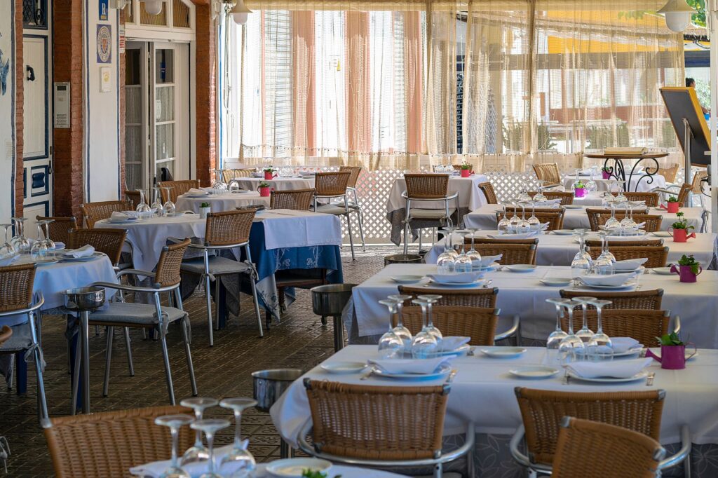 Outdoor restaurant table set for a long Spanish lunch, ready for sobremesa